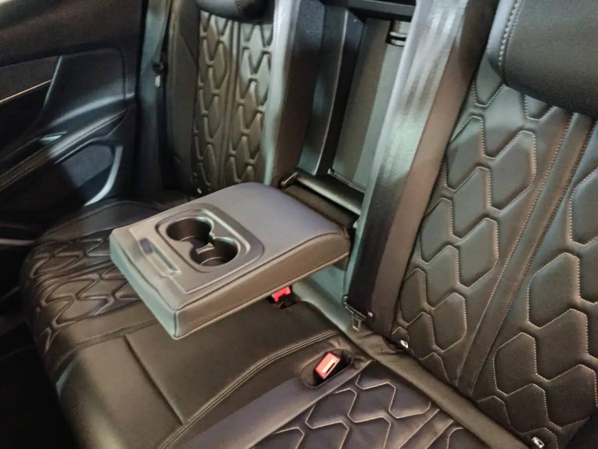 Vue rapprochée de la banquette arrière noire en cuir avec accoudoir central et porte-gobelets du Peugeot 3008 GT Pack.