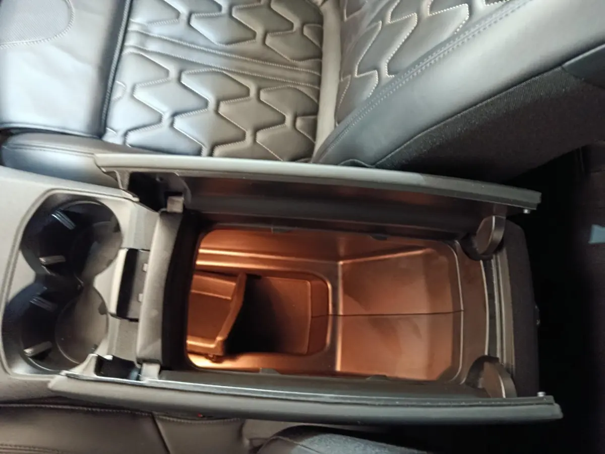 Vue plongeante sur le rangement central ouvert et les sièges en cuir noir du Peugeot 3008 hybride rechargeable bleu.