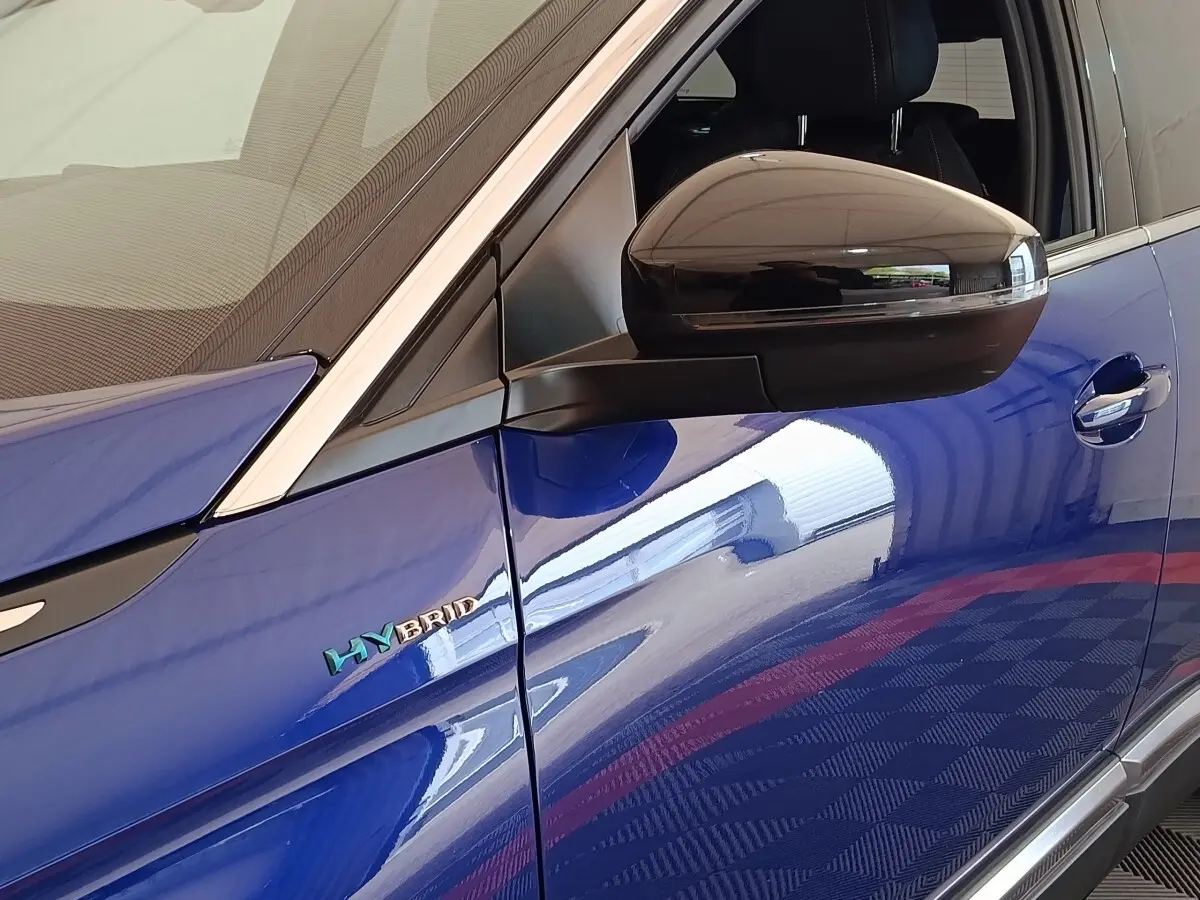 Détail du rétroviseur noir et logo HYBRID sur la porte côté gauche d’un Peugeot 3008 bleu.