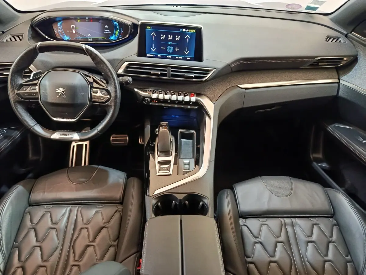 Vue intérieure avant du Peugeot 3008 GT Pack 1.6 Hybrid 225, avec tableau de bord numérique et sièges cuir noirs.