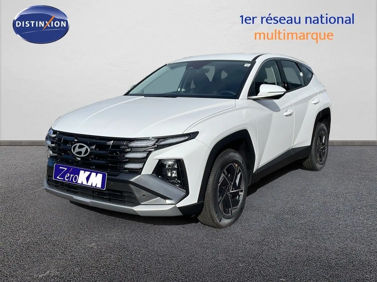 Hyundai Tucson blanc atlas vu en 3/4 avant droit, avec calandre noire et jantes foncées distinctives.