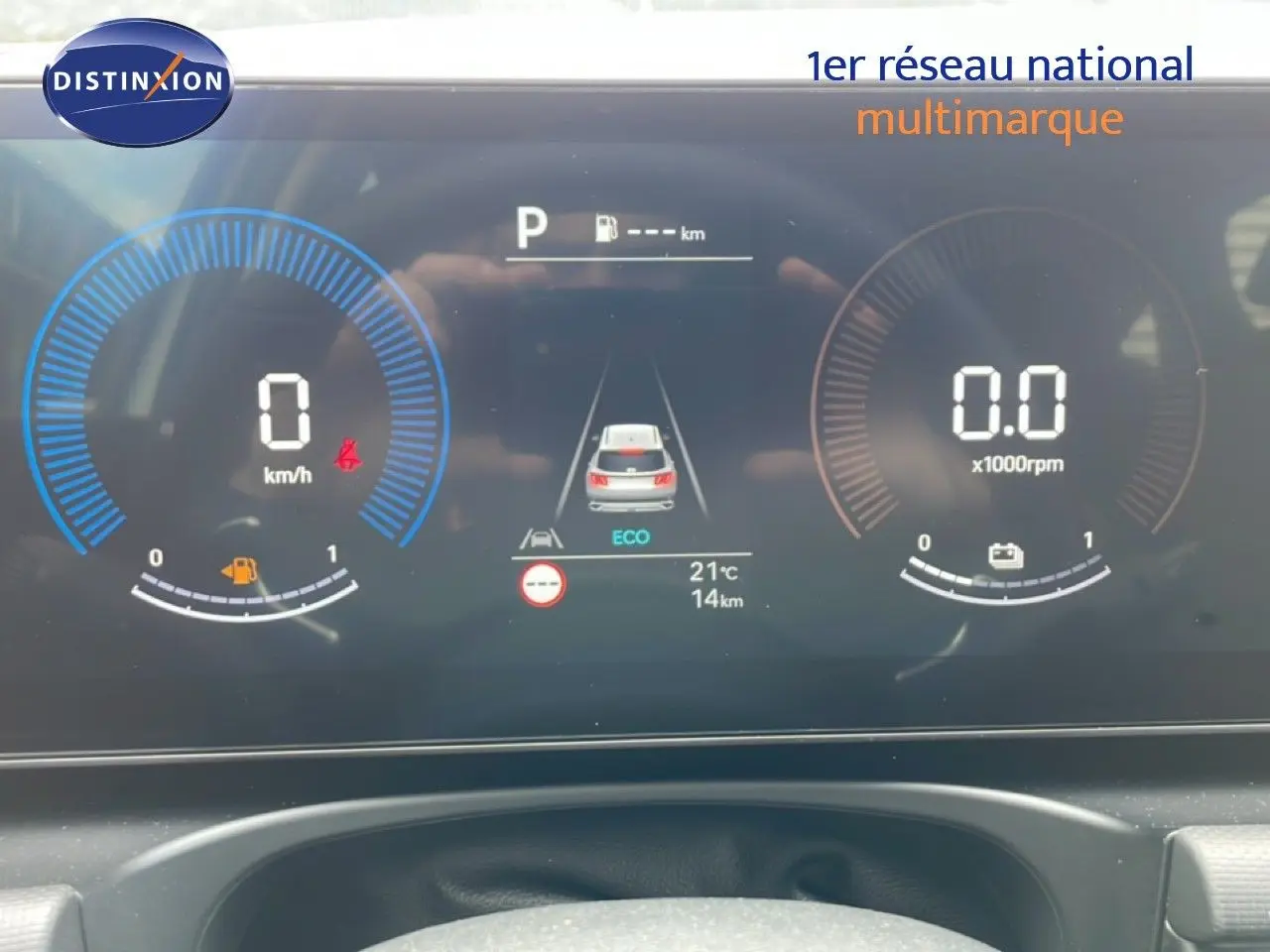 Tableau de bord numérique du Hyundai Tucson blanc, affichant la vitesse à 0 km/h et mode ECO en vue frontale.
