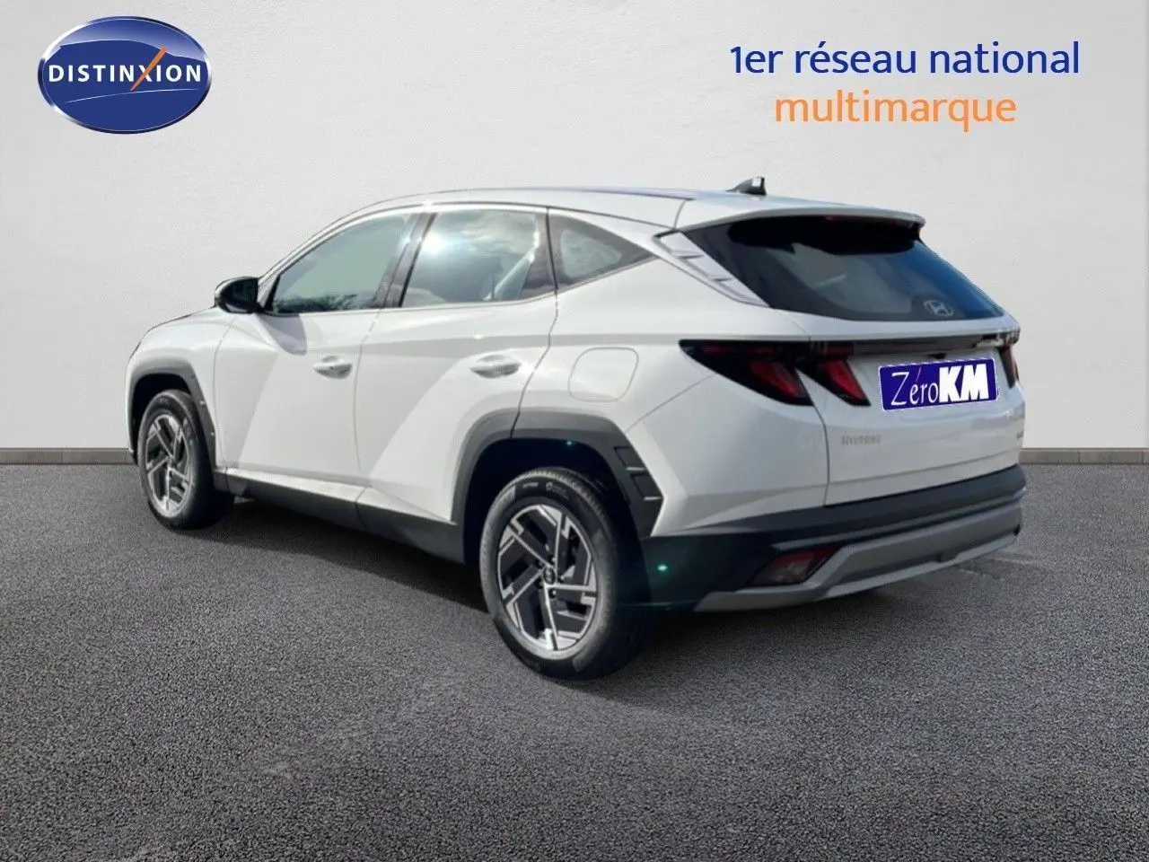 Hyundai Tucson blanc Atlas vu en 3/4 arrière droit, soulignant ses lignes modernes et ses jantes bi-ton.