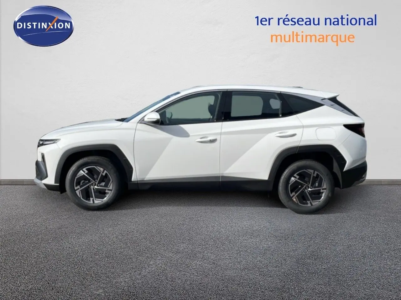 Hyundai Tucson blanc Atlas vu de profil côté gauche, soulignant ses lignes anguleuses et ses jantes bi-ton.
