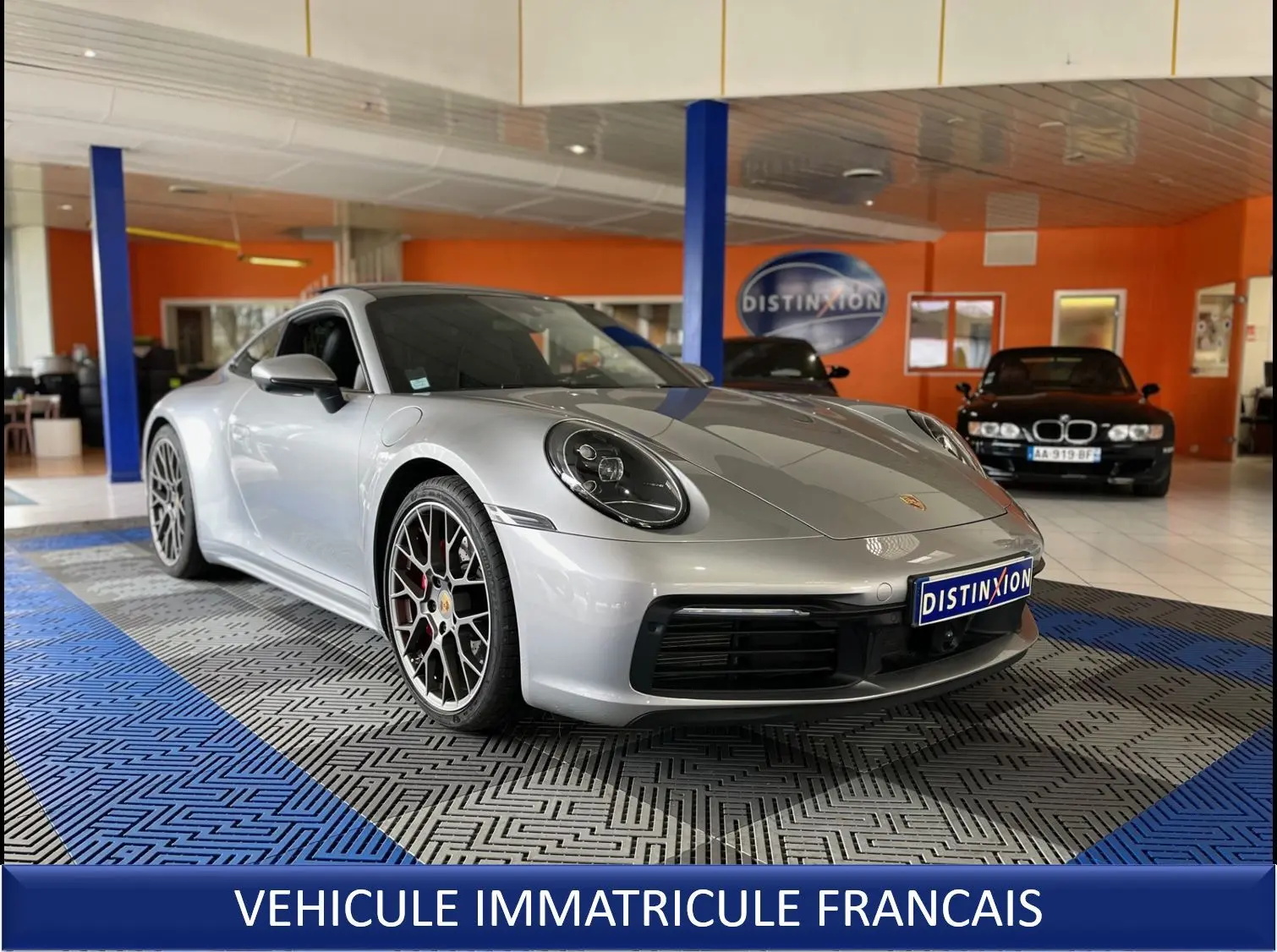 Porsche 911 (992) Carrera S argent GT vue 3/4 avant droit, jantes RS Spyder et intérieur noir visible en showroom