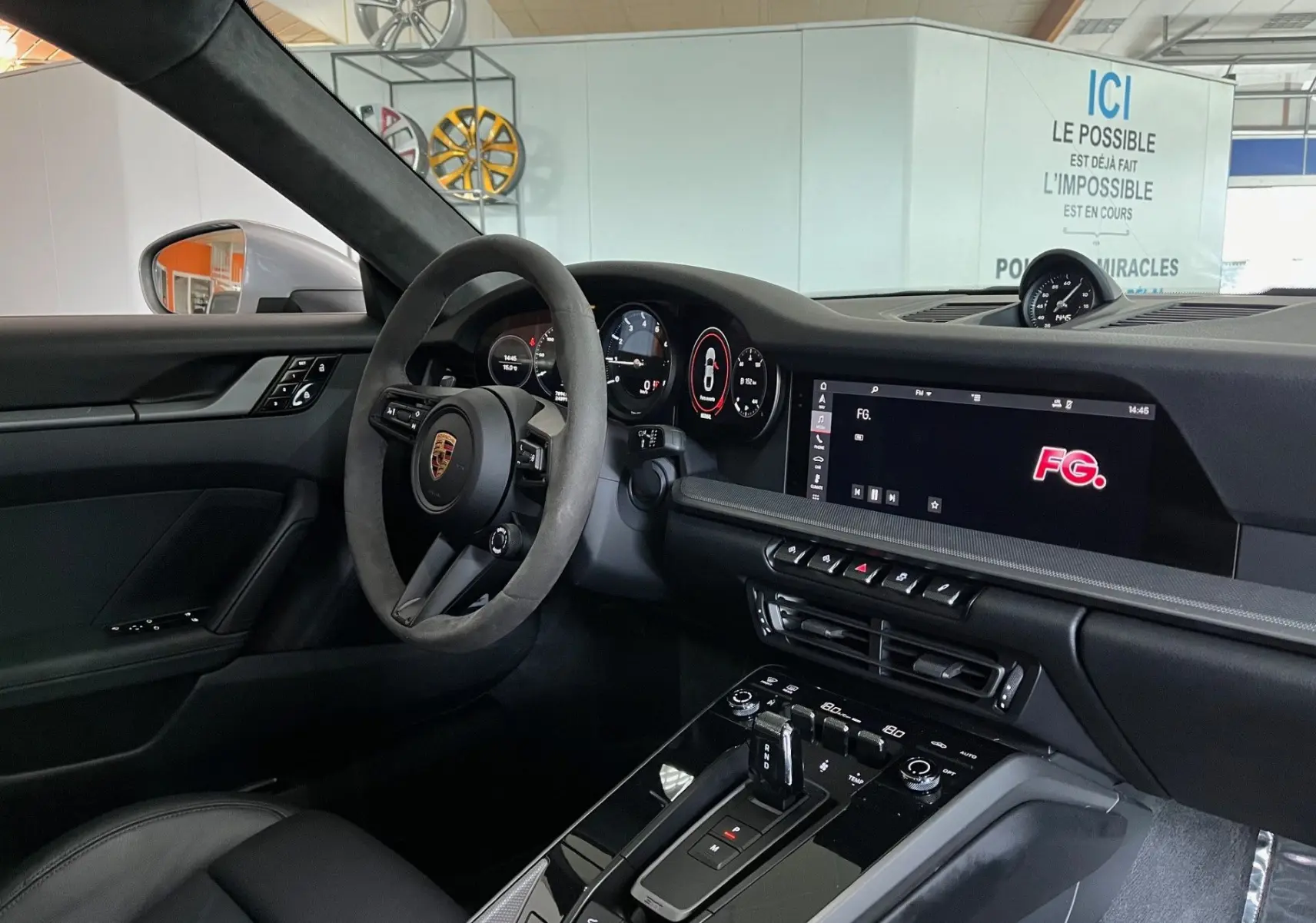 Intérieur noir de la Porsche 911 (992) Coupé, vue côté conducteur sur le tableau de bord et la console centrale moderne.