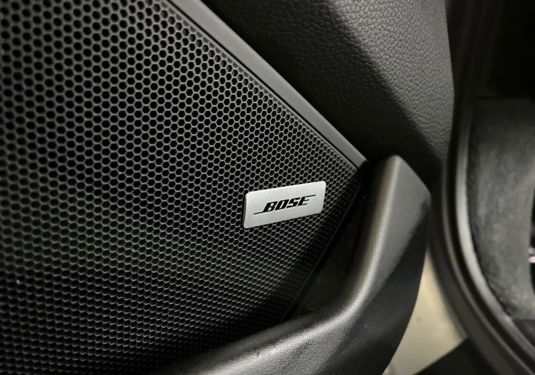 Gros plan sur l'enceinte Bose intégrée à la porte intérieure d'une Porsche 911 Carrera S argent GT.