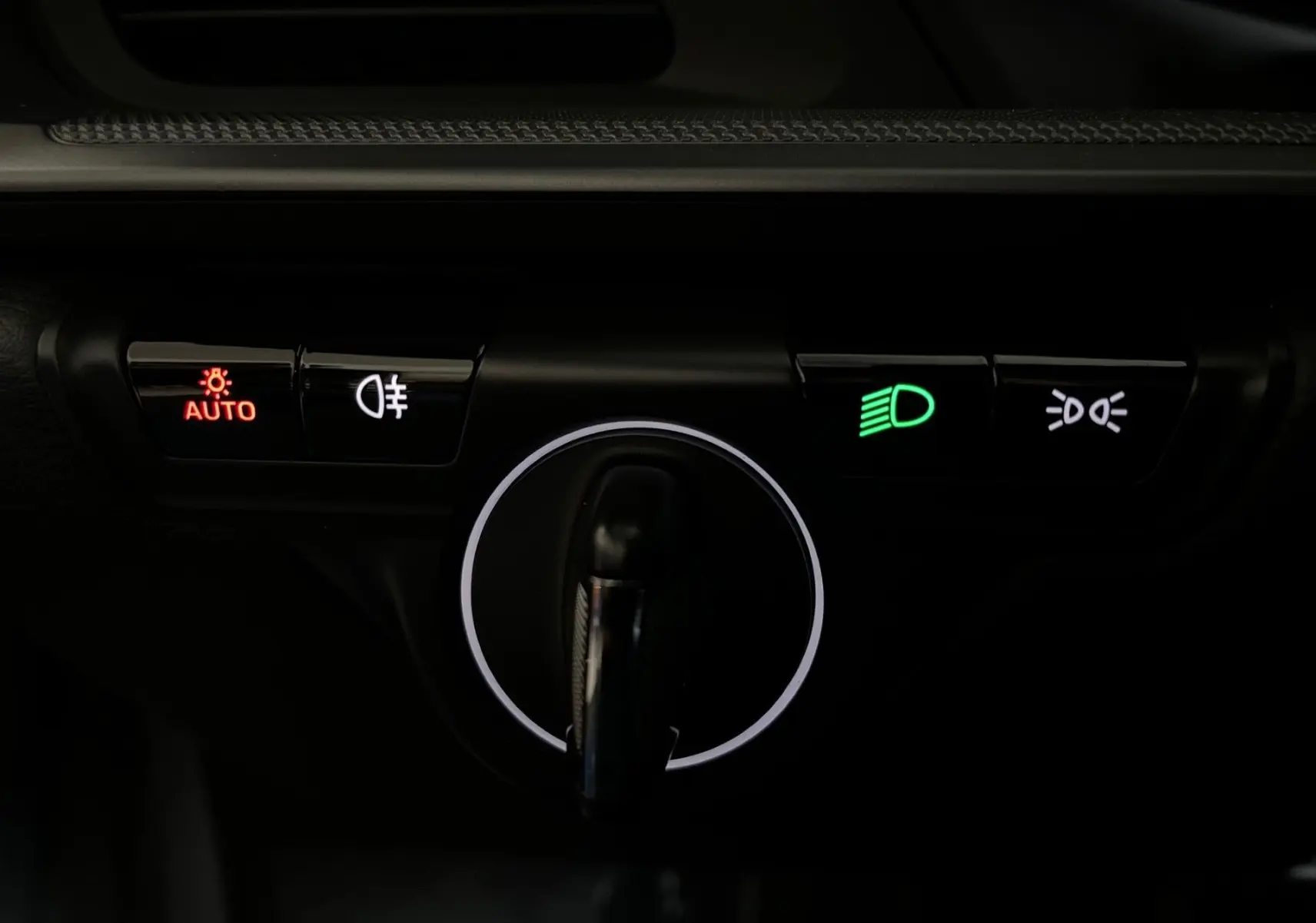 Gros plan sur la commande d’éclairage intérieur d’une Porsche 911 992 argent GT, avec voyants lumineux activés.