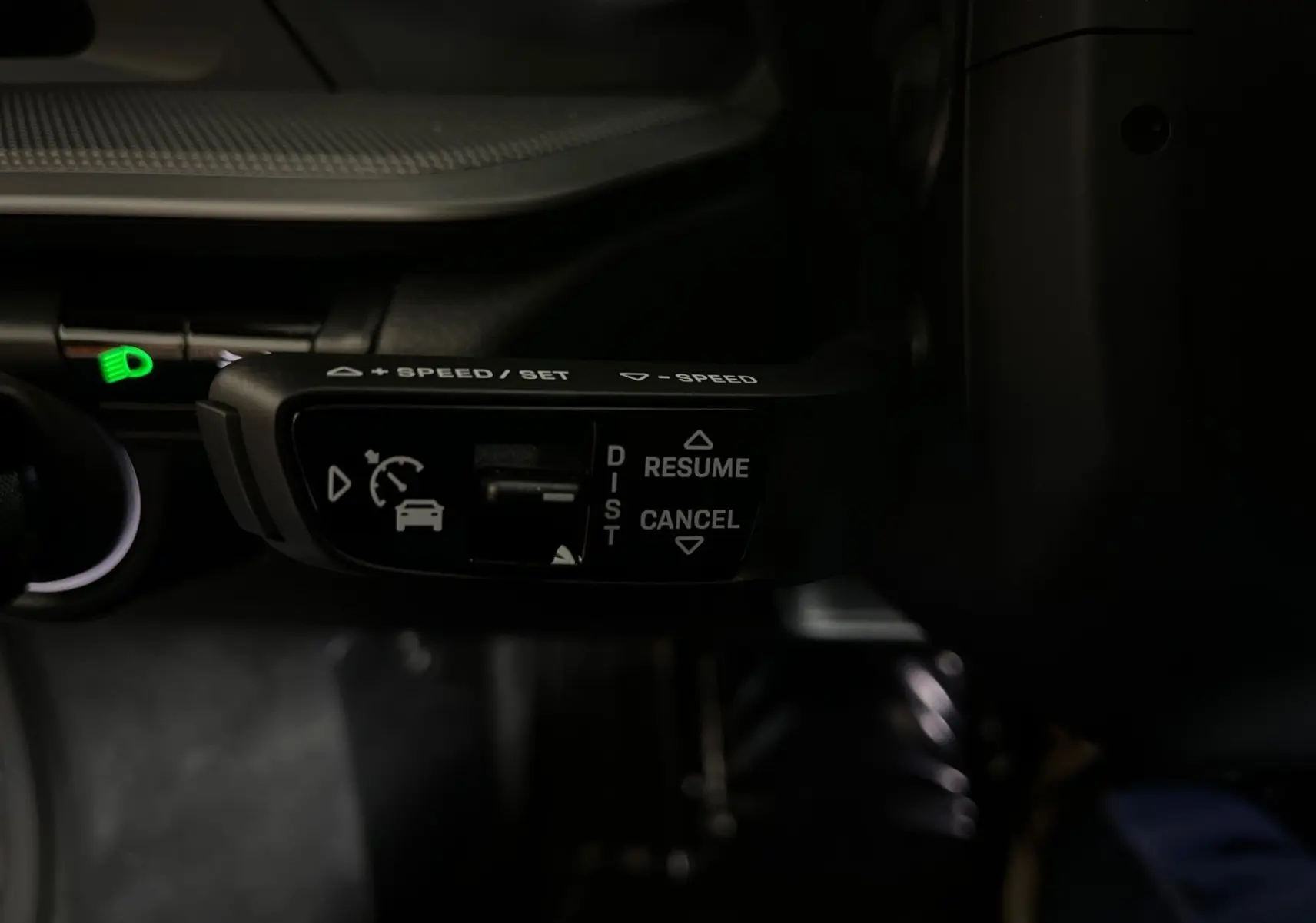 Gros plan sur la commande de régulateur de vitesse au volant d'une Porsche 911 Carrera S argent GT, intérieur noir.