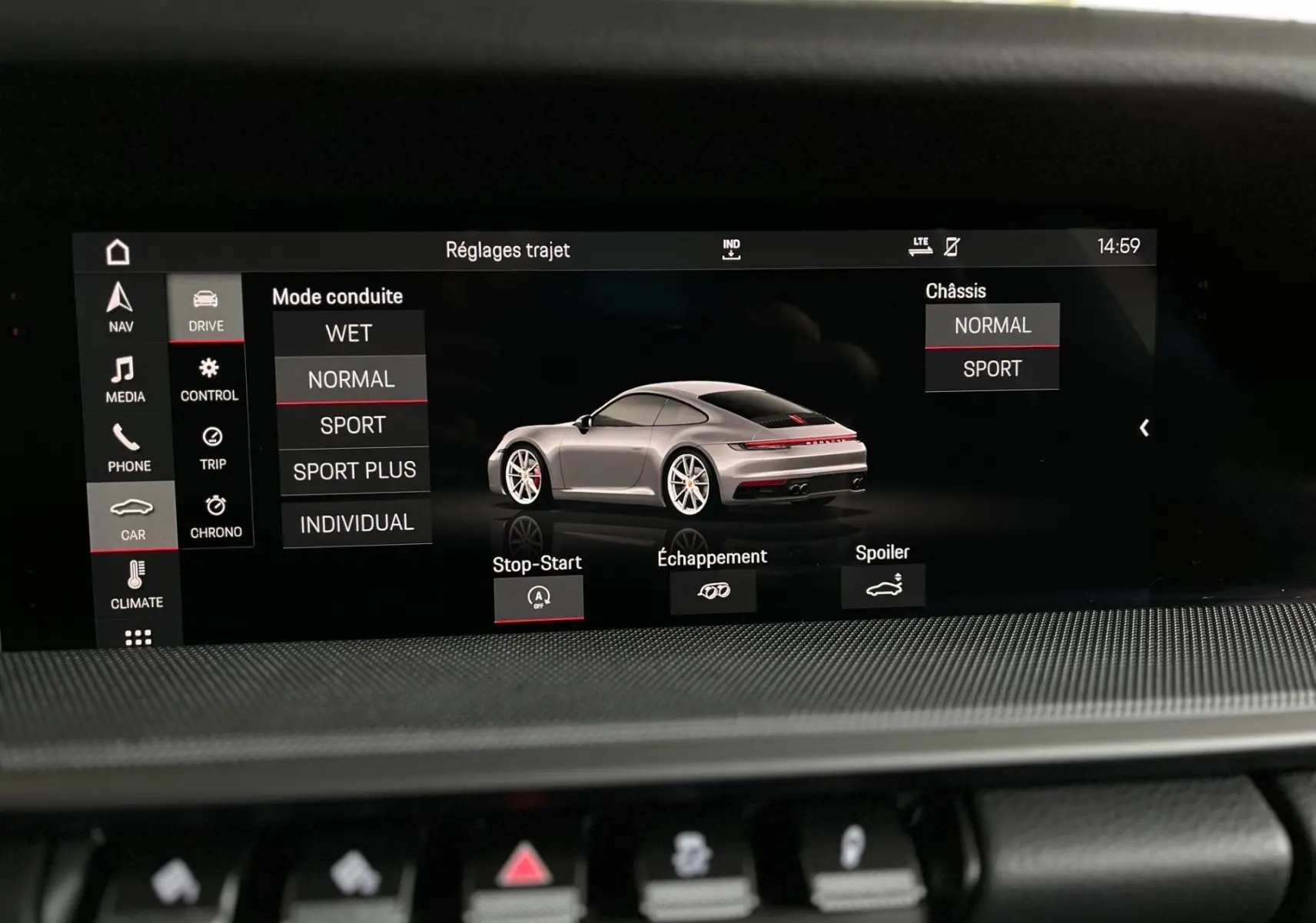 Écran intérieur affichant les réglages de conduite d'une Porsche 911 argent vue de trois quarts arrière droit.
