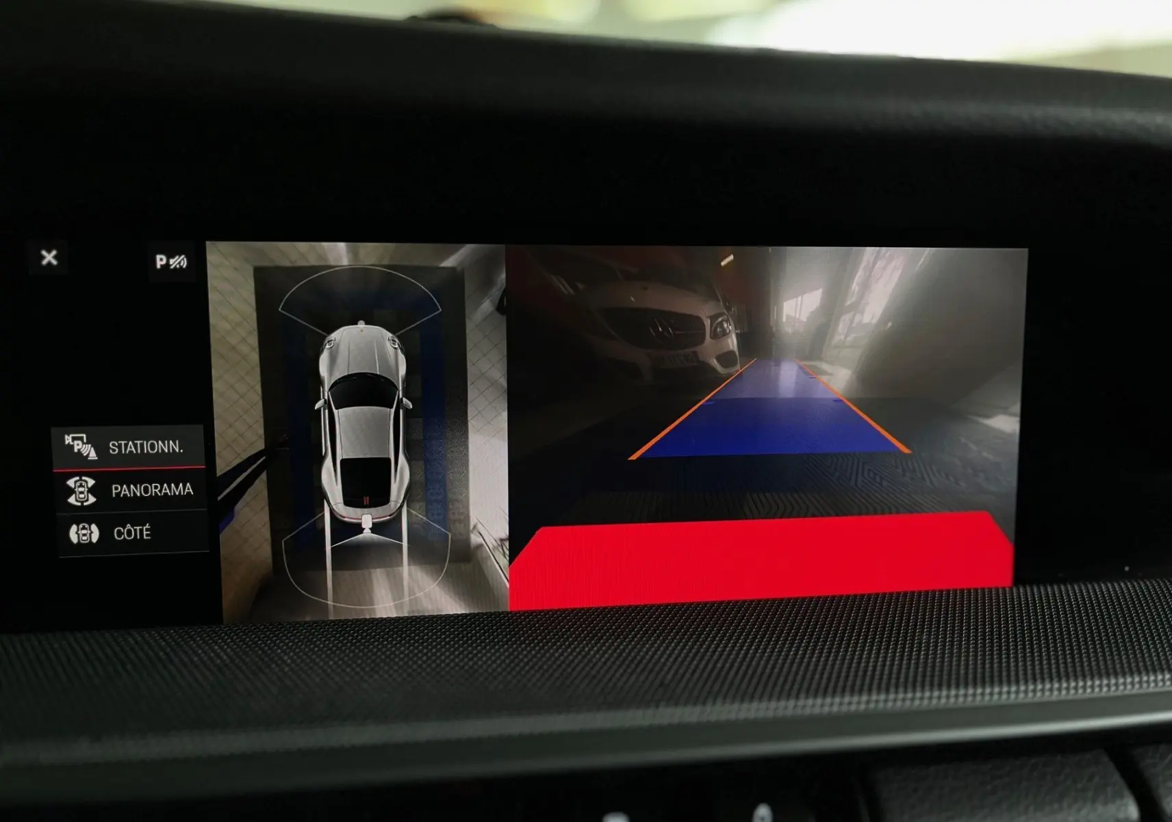 Affichage écran intérieur montrant la vue aérienne et caméra de recul d'une Porsche 911 argent GT en stationnement.