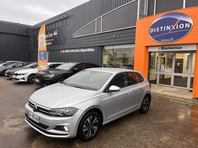 Volkswagen Polo gris Urano vue 3/4 avant droit devant un concessionnaire Distinxion.