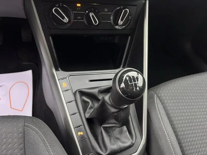 Gros plan sur le levier de vitesses manuel noir et la console centrale grise de la Volkswagen Polo 2021.