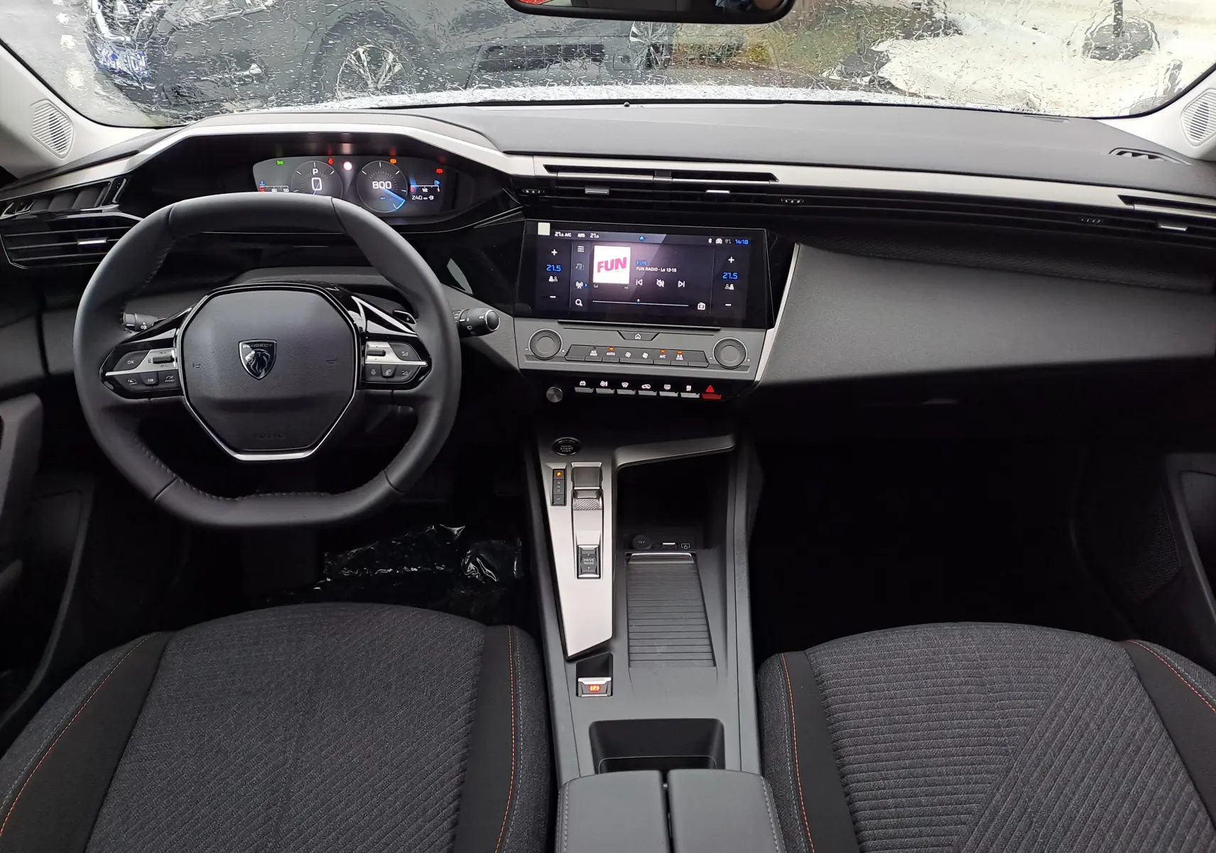 Intérieur de la Peugeot 308 2025 vue de face, tableau de bord moderne avec écran tactile et volant compact noir.