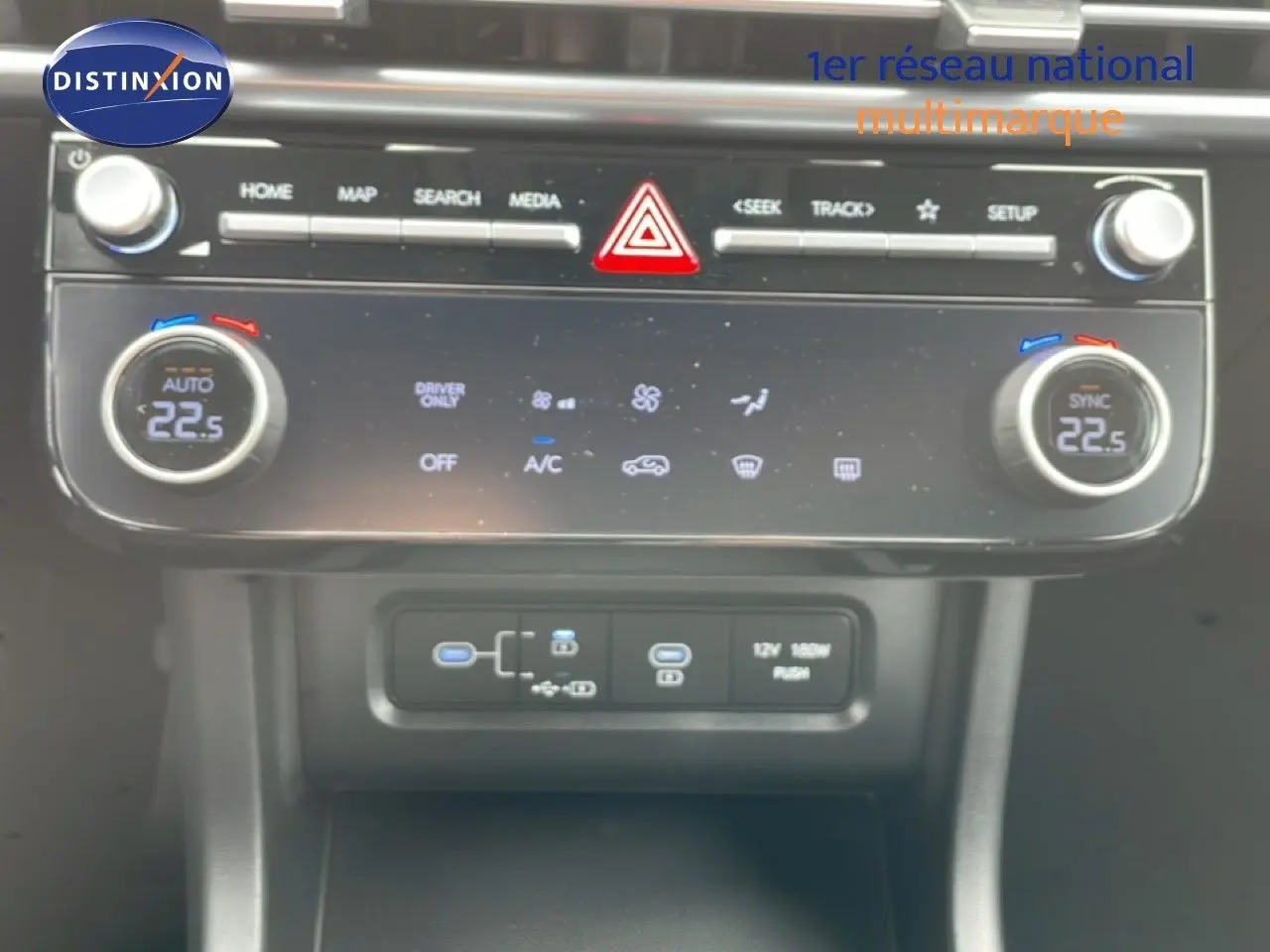Vue rapprochée de la console centrale du Hyundai Tucson blanc, affichant la climatisation digitale à 22,5°C.