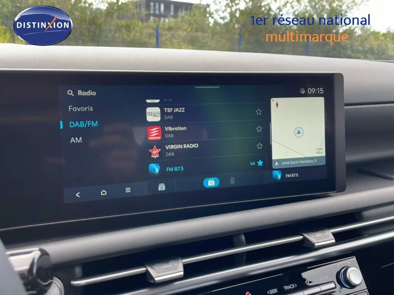 Vue rapprochée de l'écran multimédia du Hyundai Tucson blanc Atlas, affichant la radio DAB/FM et la navigation.
