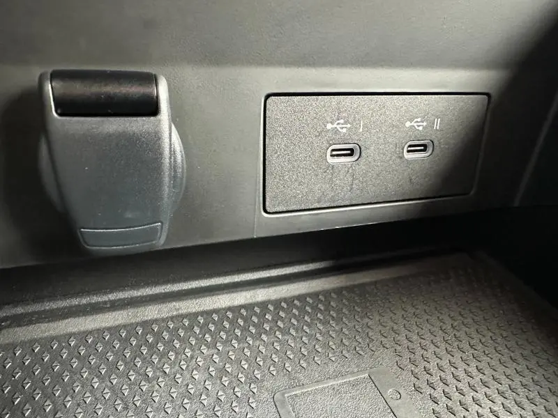 Gros plan sur les deux ports USB-C et une prise 12V noirs dans l'habitacle du Renault Captur Rouge Flamme 2025.