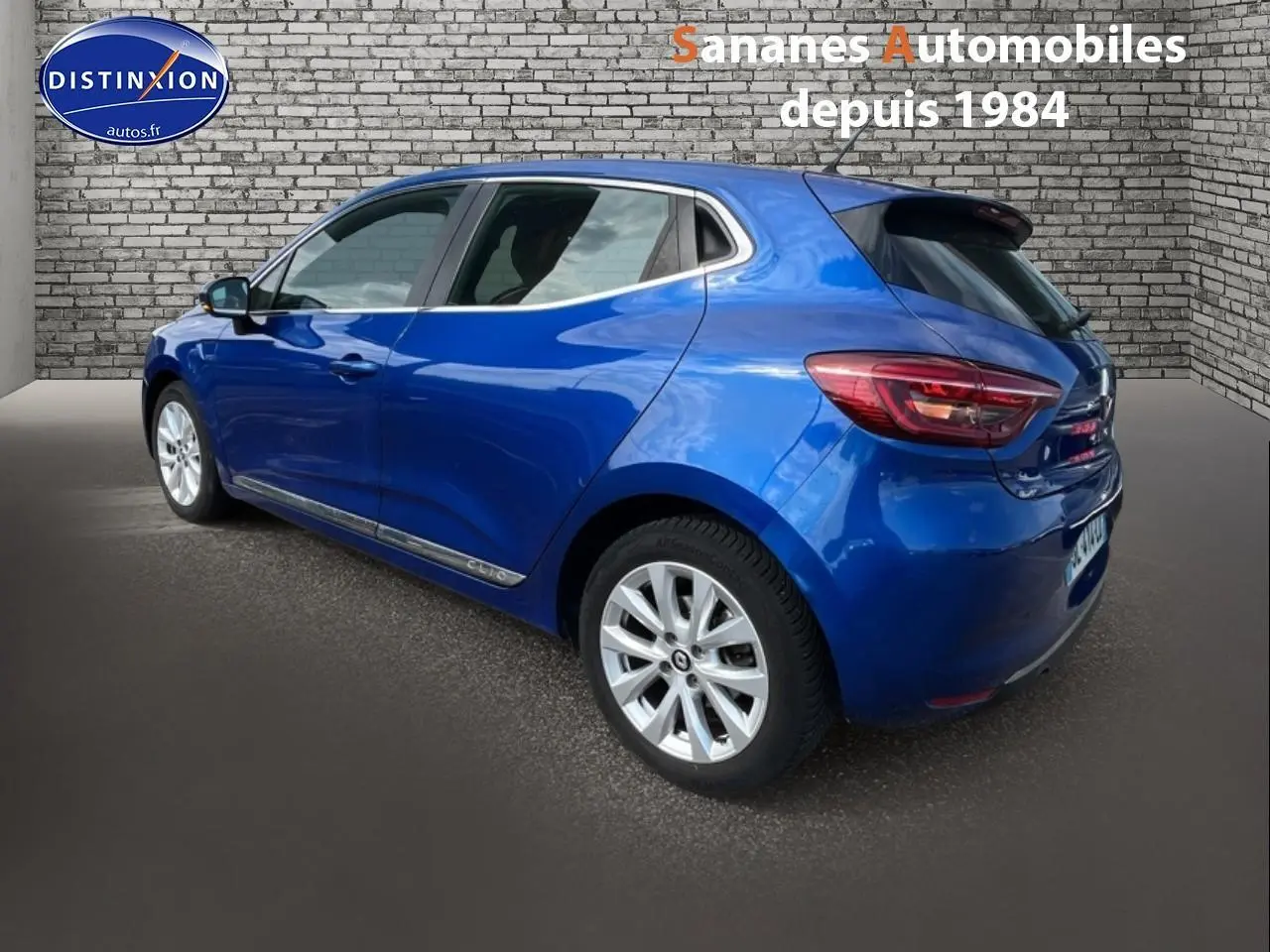 Renault Clio Bleu Iron vue 3/4 arrière droit, jantes alliage 16 pouces et feux arrière LED visibles.