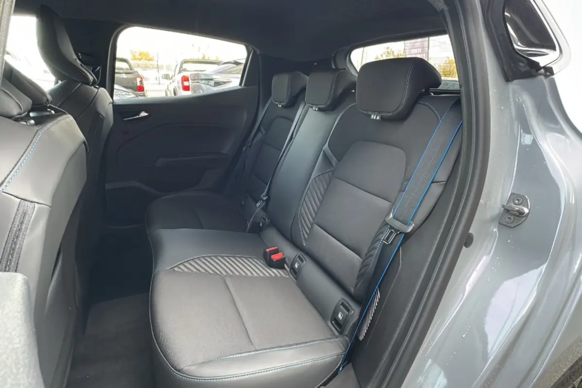 Vue intérieure arrière côté droit de la Renault Clio V E-Tech 145 Esprit Alpine Bose avec sellerie noire et surpiqûres bleues.