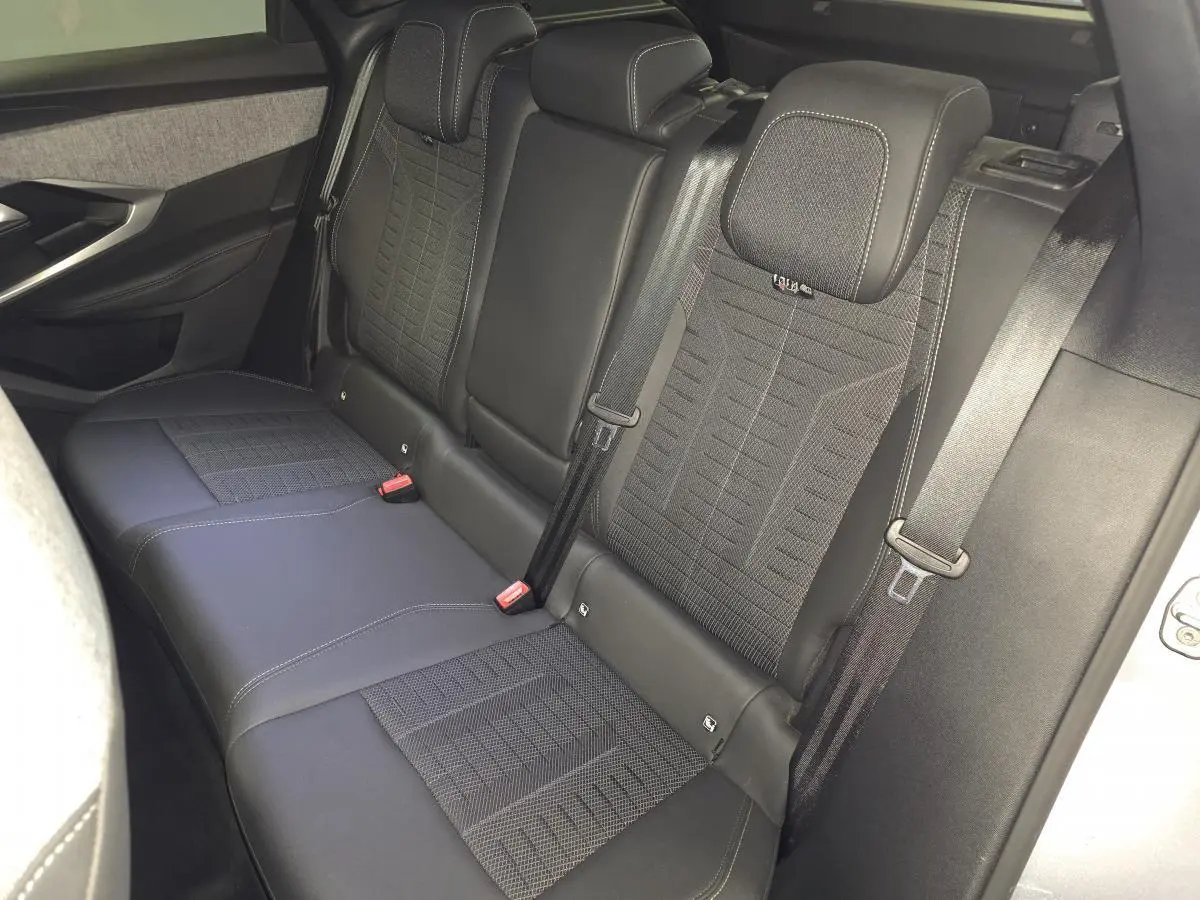 Vue intérieure côté droit des sièges arrière noirs en tissu et cuir du Peugeot 3008 2025 hybride.