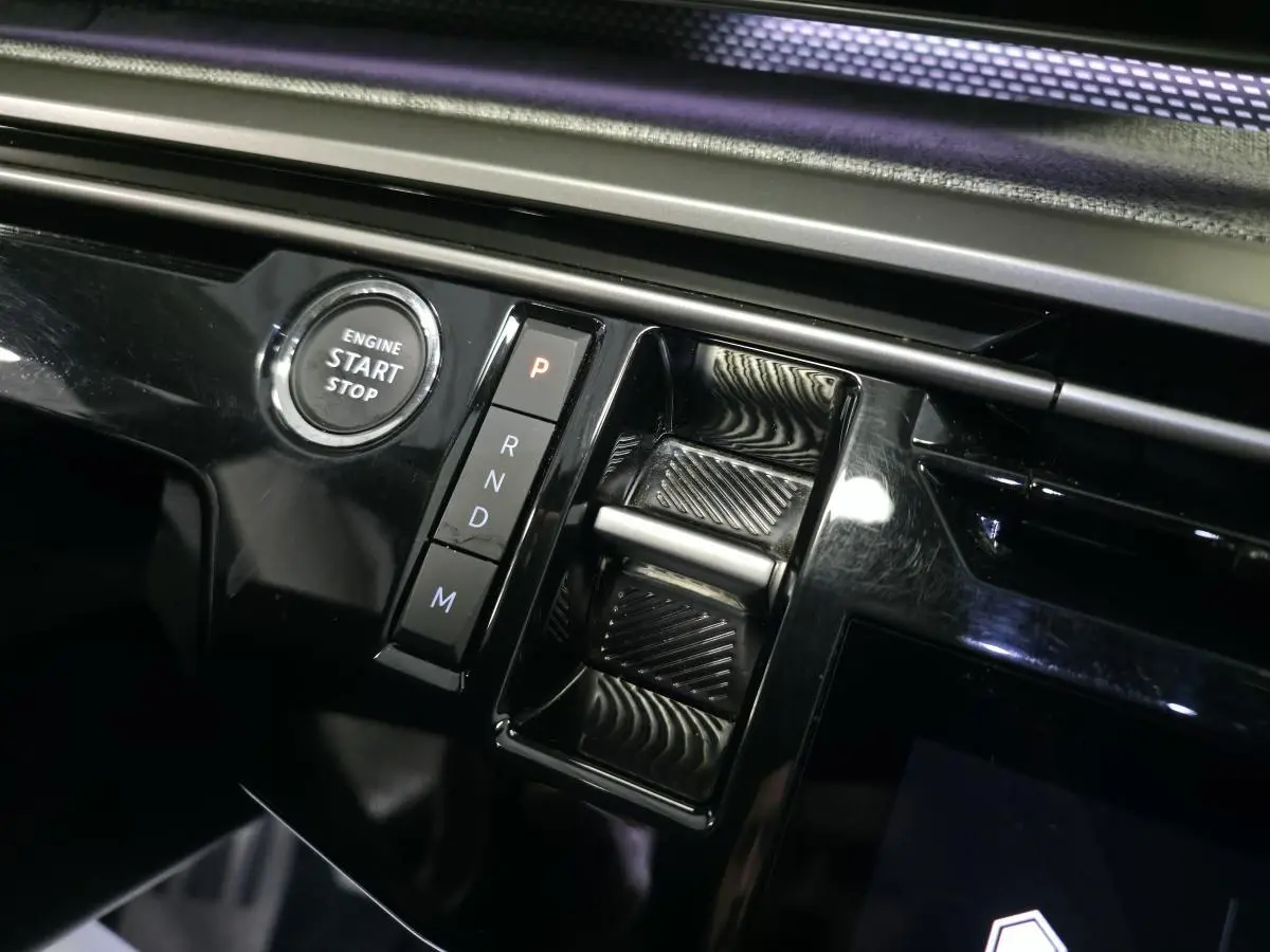Gros plan sur la console centrale noire brillante du Peugeot 3008 2025 avec bouton start/stop et sélecteur de boîte automatique.