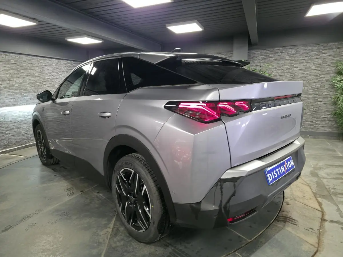 Vue 3/4 arrière droite du Peugeot 3008 gris métallisé avec feux arrière à griffes LED et jantes alliage noires.