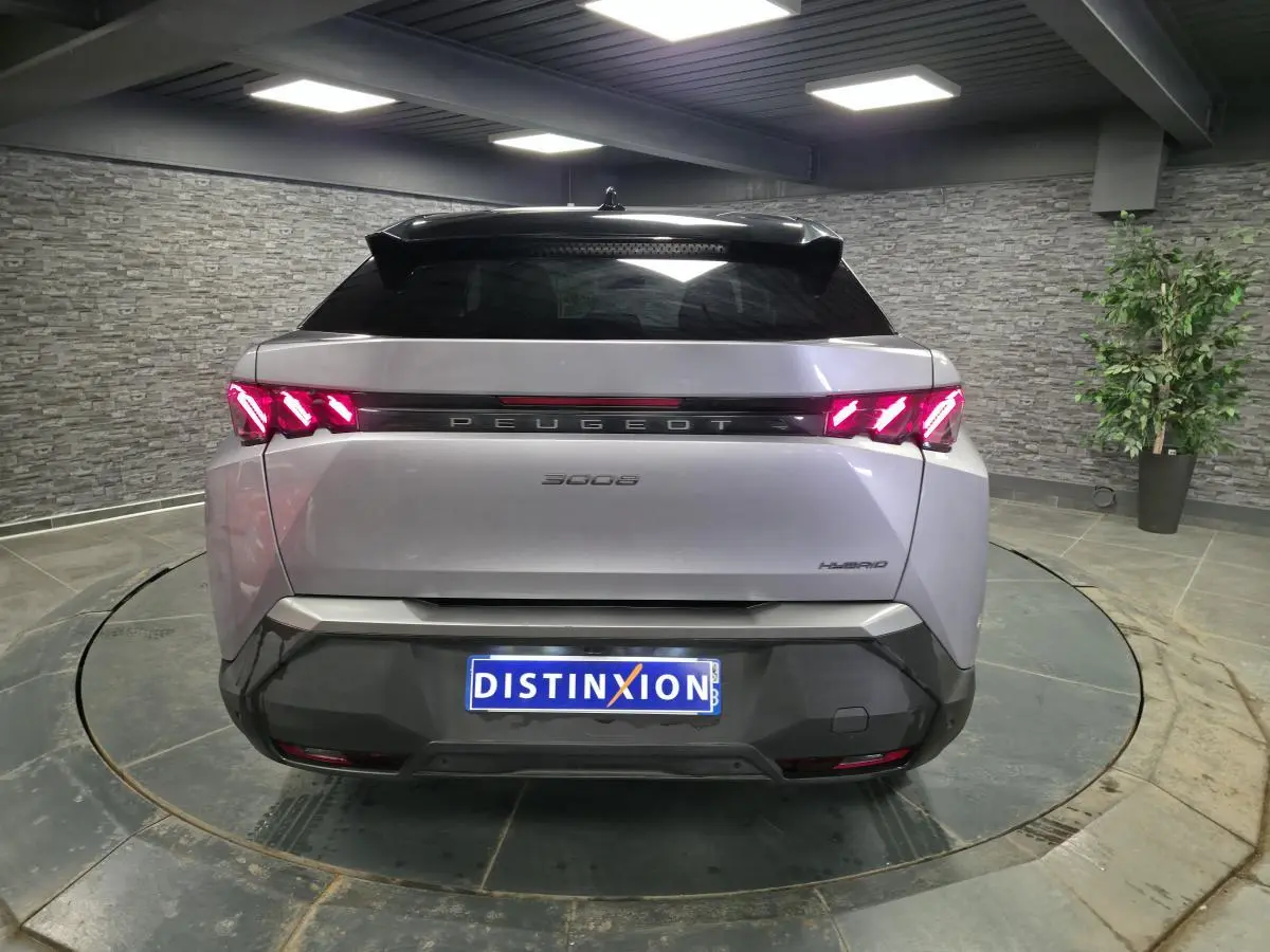 Vue arrière d’un Peugeot 3008 gris hybride 2025 avec feux arrière à griffes LED et bandeau noir laqué.