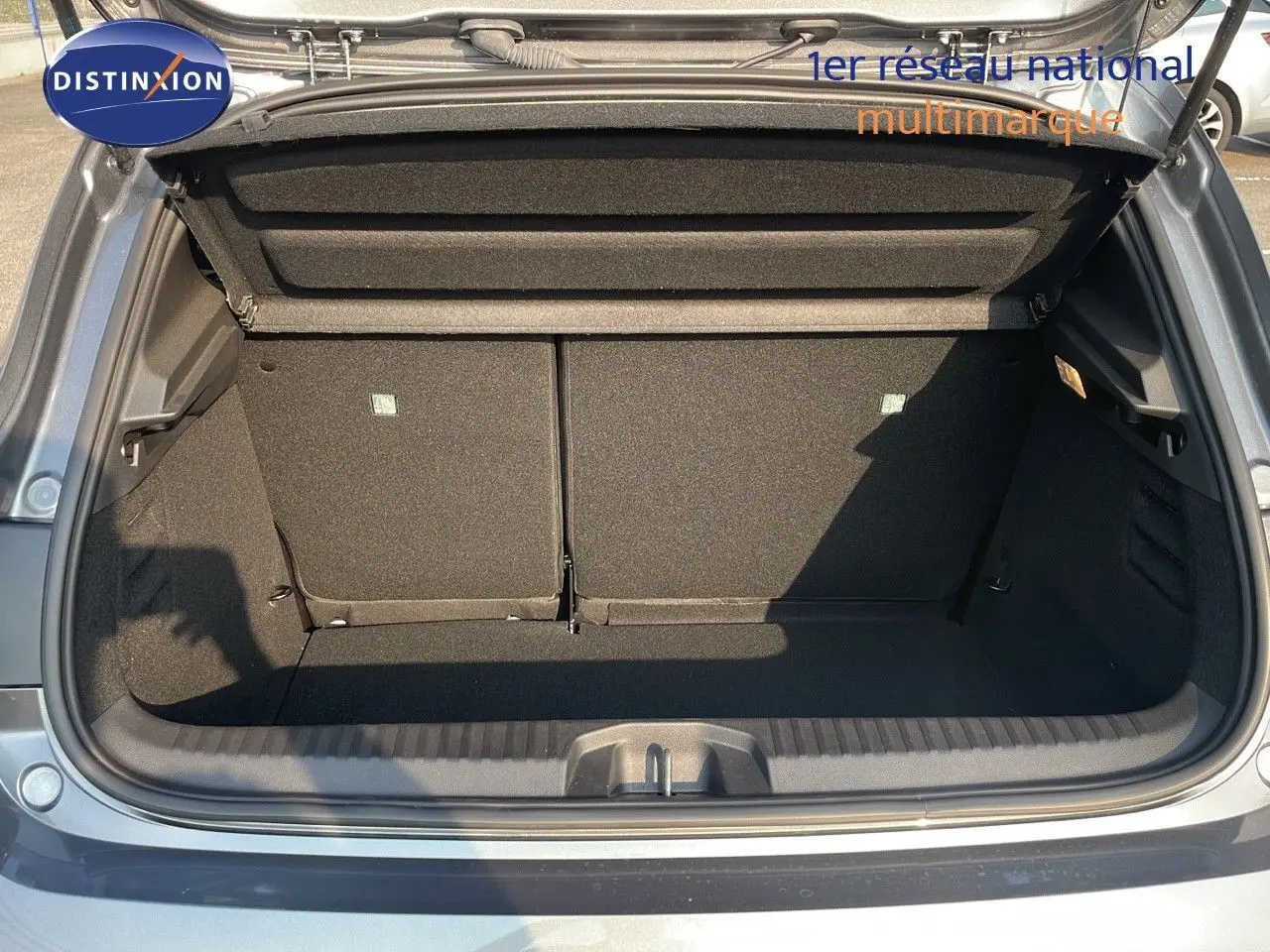 Coffre ouvert d'une Renault Clio gris schiste métal, vue arrière montrant l'espace de chargement vide.