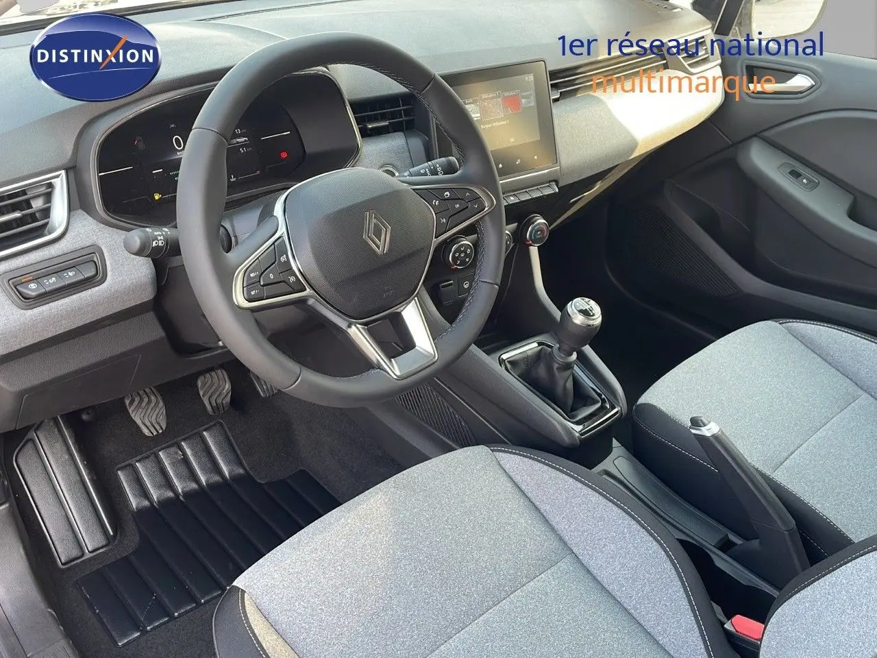 Vue intérieure de la Renault Clio V BluedCi 100ch Evolution 2025, montrant le volant, la boîte manuelle et les sièges gris clair.