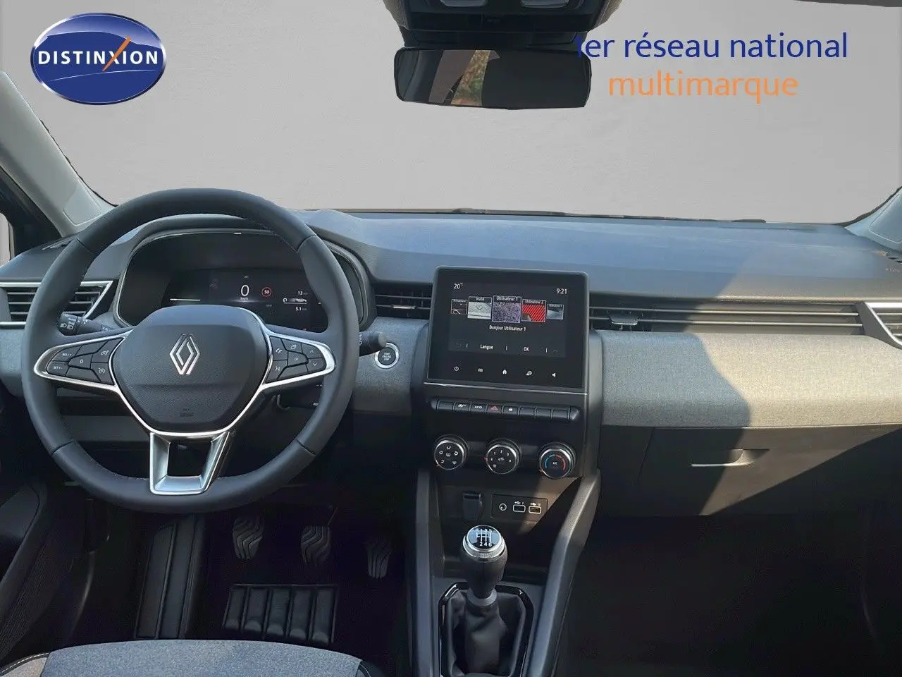 Vue intérieure avant de la Renault Clio V BlueDCI 100ch Evolution 2025, tableau de bord gris et volant cuir multifonction.