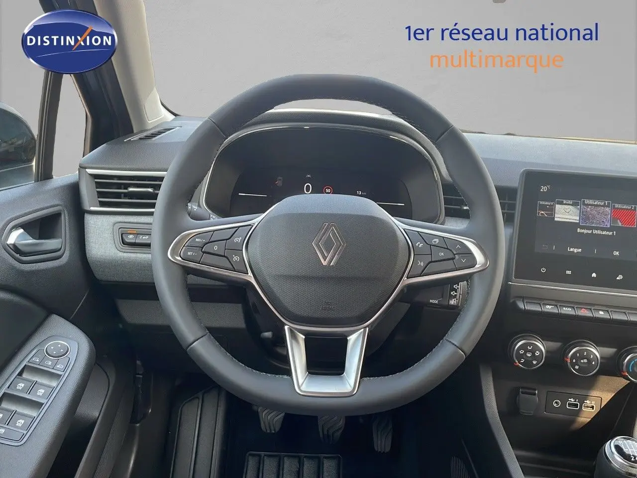 Vue centrée du volant cuir et du tableau de bord numérique d'une Renault Clio gris schiste 2025, avec écran tactile.