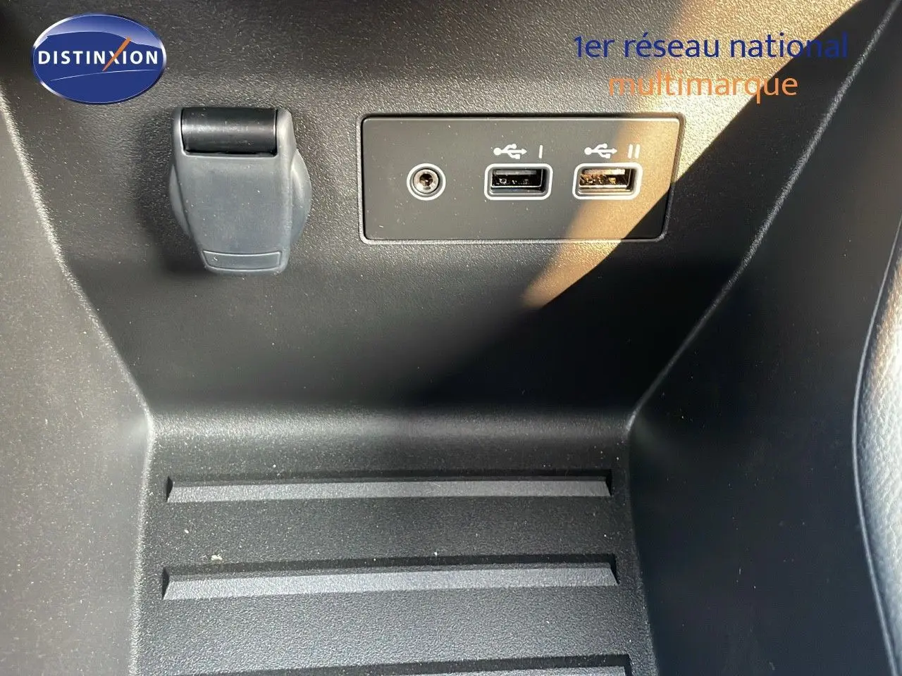 Détail intérieur montrant les ports USB et prise auxiliaire sur la console centrale d’une Renault Clio gris schiste 2025.