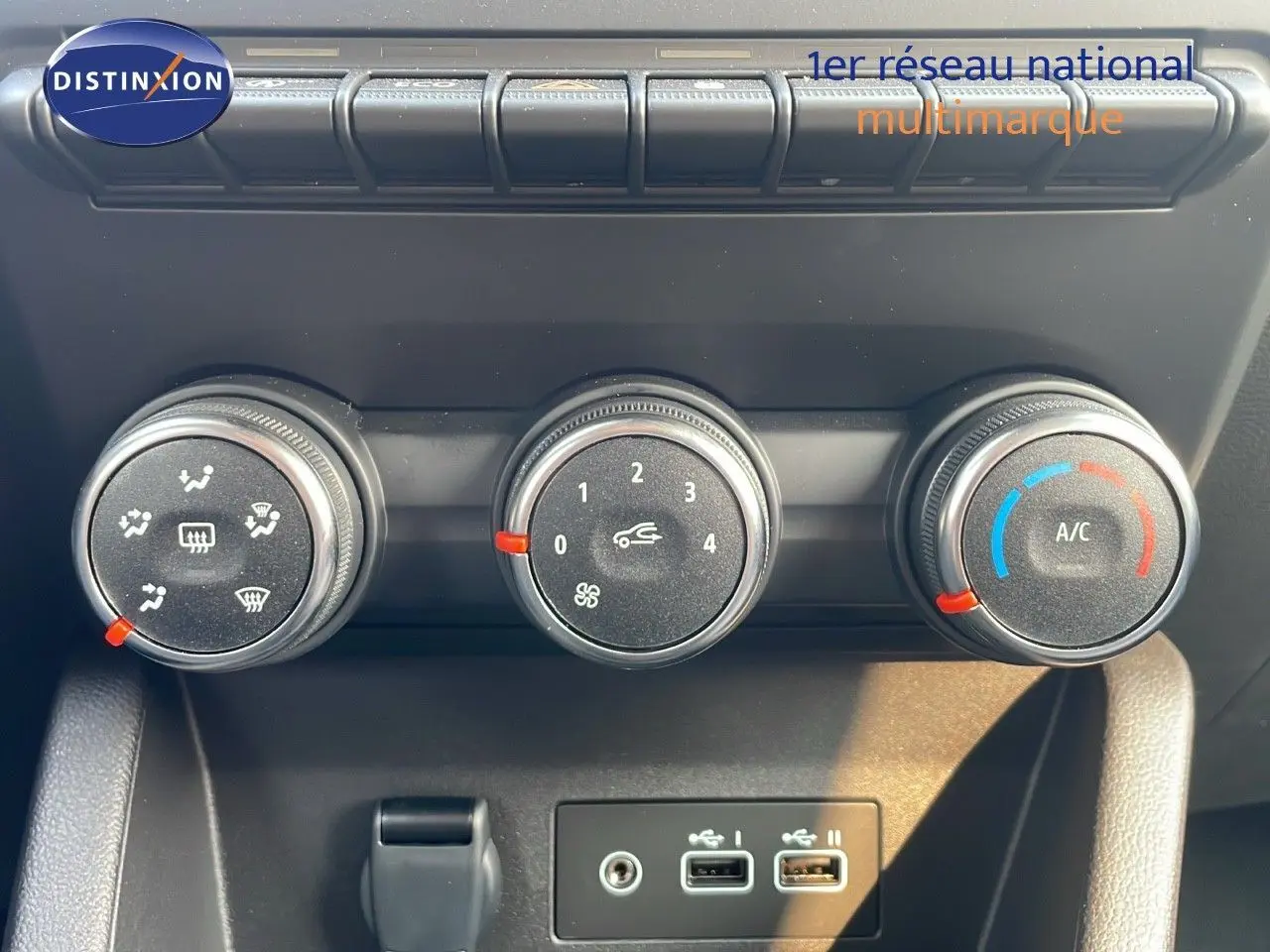 Gros plan sur les commandes de climatisation manuelle avec trois boutons rotatifs dans une Renault Clio gris schiste.