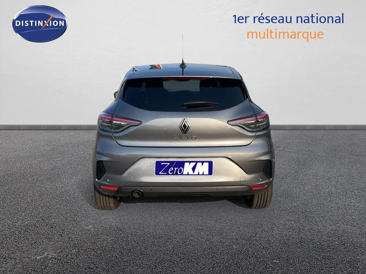 Vue arrière d’une Renault Clio gris schiste métal 2025 avec feux LED et plaque Zero KM visible.