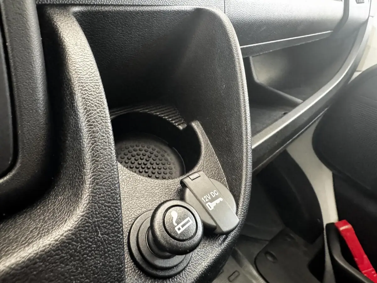 Gros plan intérieur sur la prise 12V et allume-cigare du Citroën Jumper blanc, côté passager avant.
