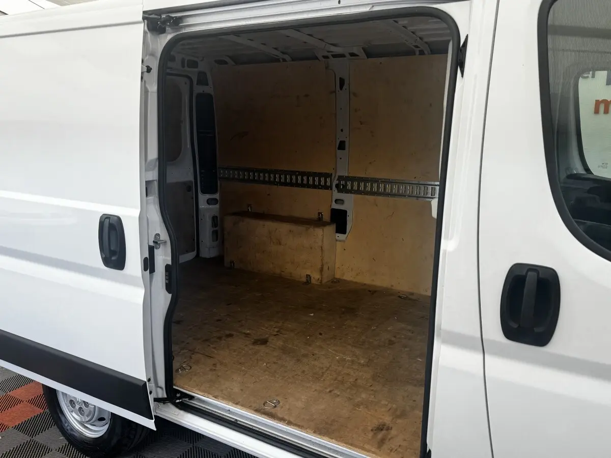 Vue latérale gauche d’un Citroën Jumper blanc 2023 avec porte coulissante ouverte montrant l’espace de chargement vide.