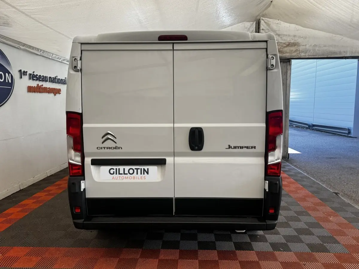 Vue arrière d’un utilitaire blanc Citroën Jumper 33 L1H1, portes fermées avec logo et plaque GILLOTIN.
