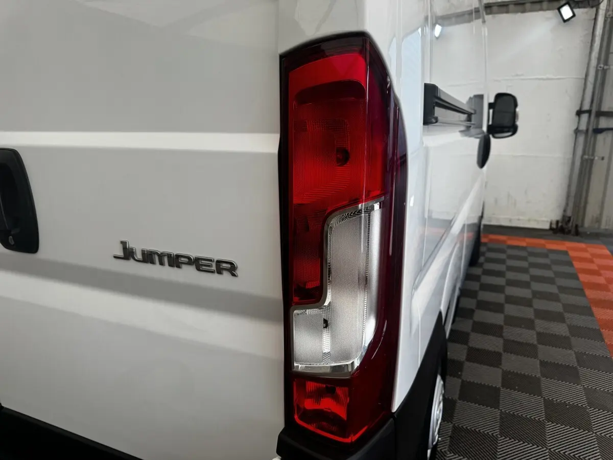 Vue arrière droite du Citroën Jumper blanc 2023, mettant en valeur le feu arrière et le logo Jumper sur la porte.