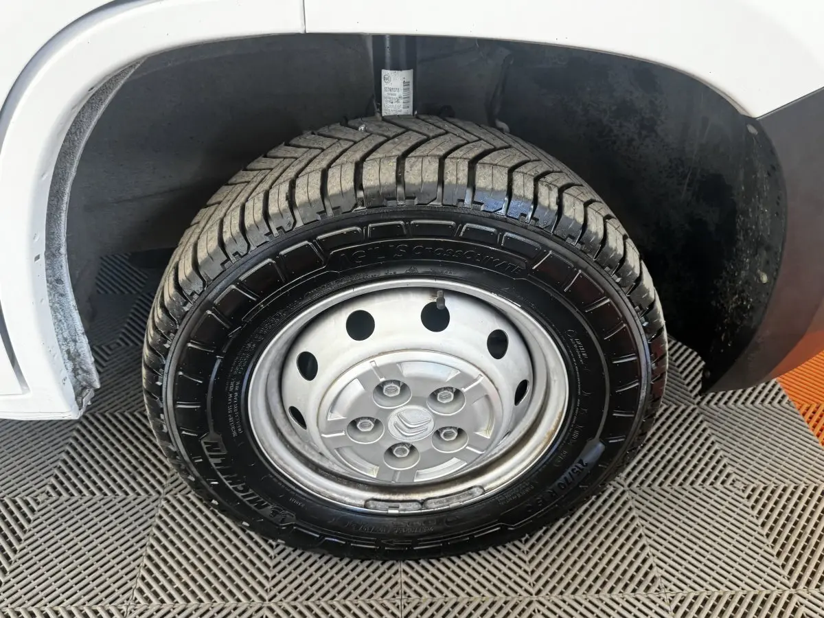 Gros plan sur la roue avant gauche acier d’un Citroën Jumper blanc, montrant le pneu Michelin et l’aile du véhicule.