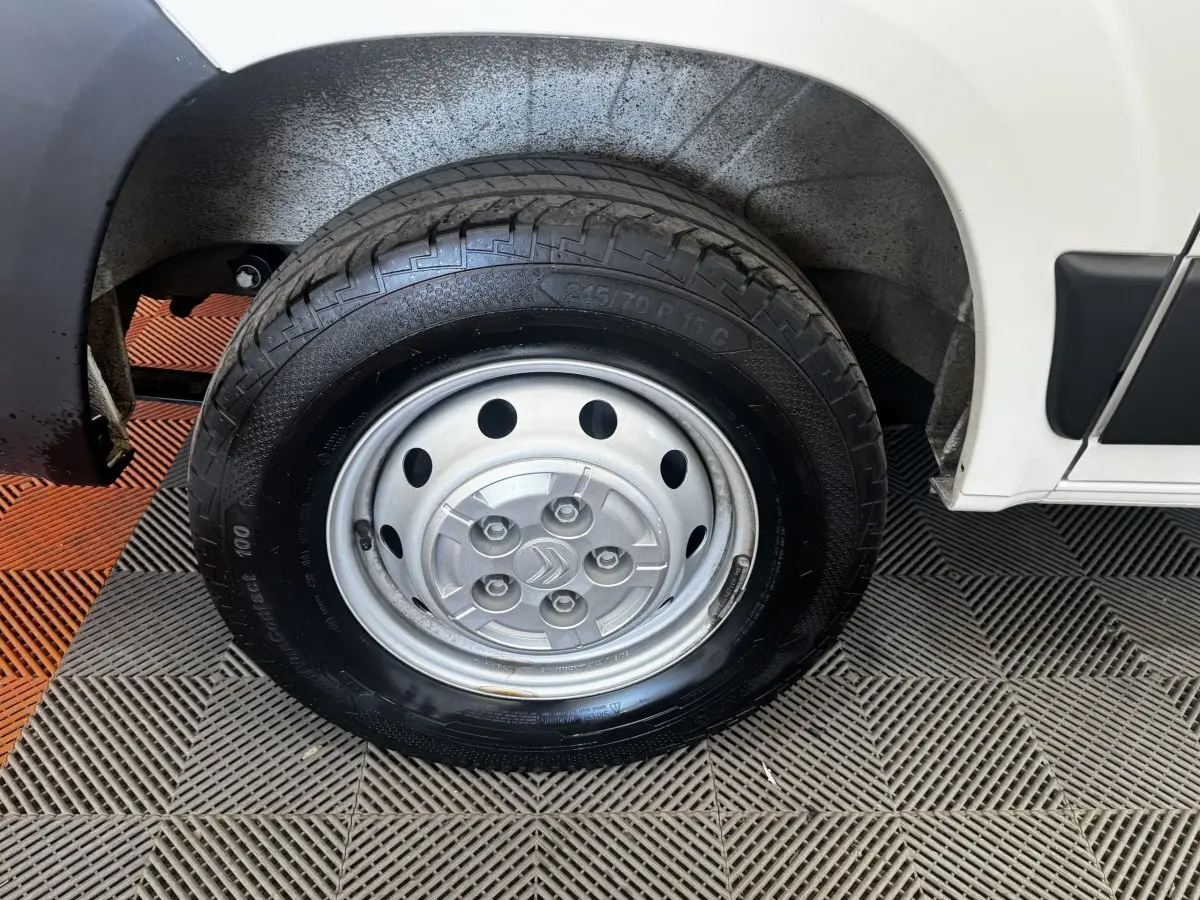 Gros plan sur la roue arrière droite en jante acier argentée du Citroën Jumper blanc, avec partie basse de la carrosserie visible.