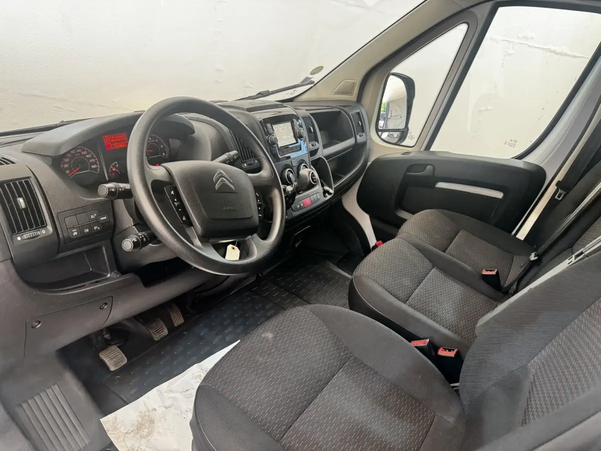 Vue intérieure côté conducteur du Citroën Jumper 2023, volant multifonctions et tableau de bord avec écran tactile.
