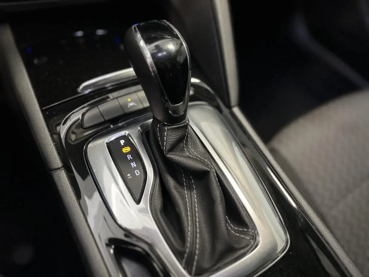 Le levier de vitesses automatique noir avec surpiqûres blanches dans l'habitacle de l'Opel Insignia gris.