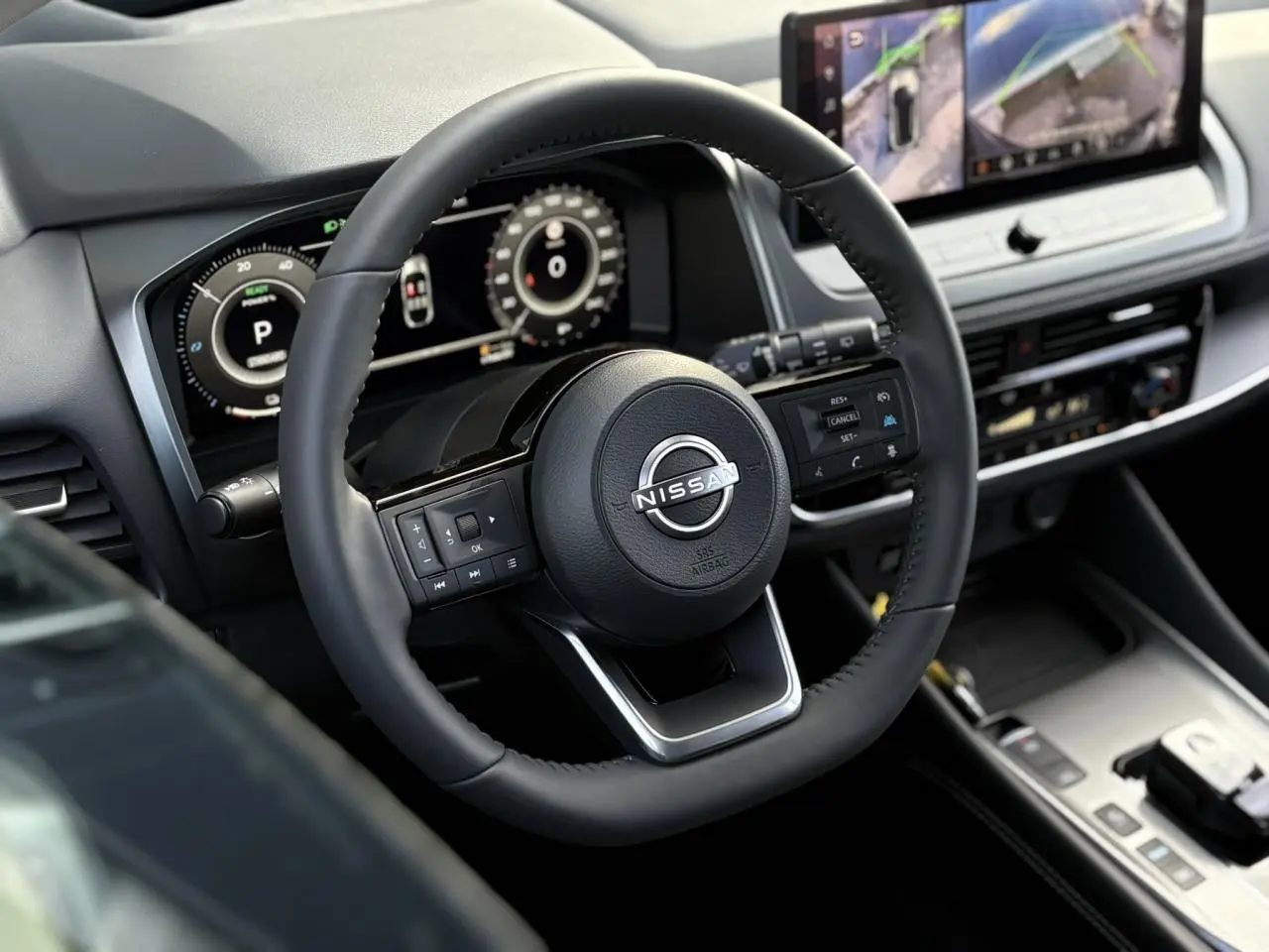 Vue rapprochée du volant noir et du tableau de bord numérique du Nissan Qashqai III e-Power 2025, avec écran tactile central.