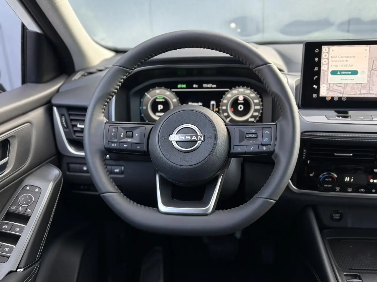 Vue frontale du volant cuir noir du Nissan Qashqai 2025 avec tableau de bord numérique et écran tactile central.