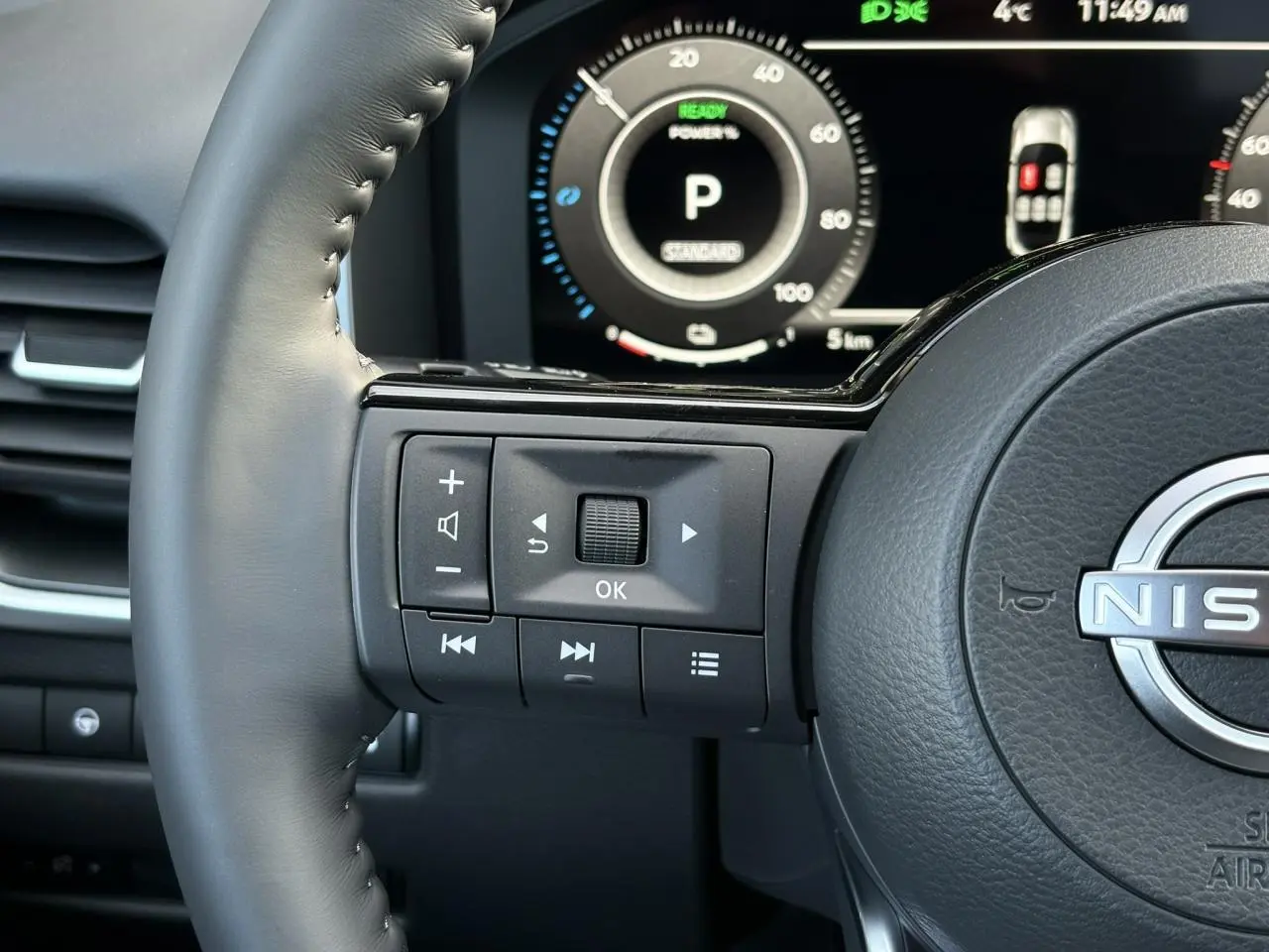 Gros plan sur le volant cuir noir du Nissan Qashqai 2025 avec commandes multifonctions et tableau de bord numérique.