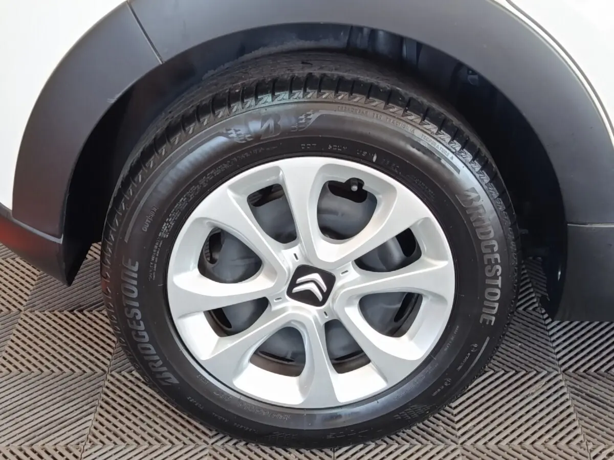 Gros plan sur la roue avant droite blanche d'une Citroën C3 avec jante alliage et pneu Bridgestone.