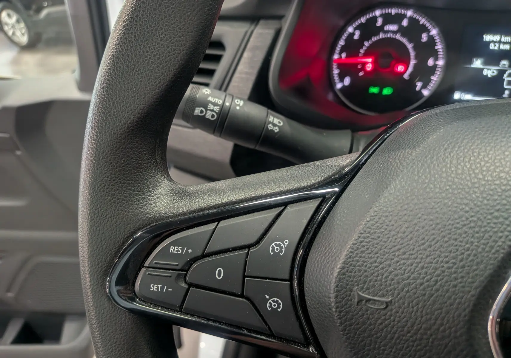 Gros plan sur le volant côté gauche du Renault Trafic Fourgon 2024, montrant les commandes de régulateur de vitesse.