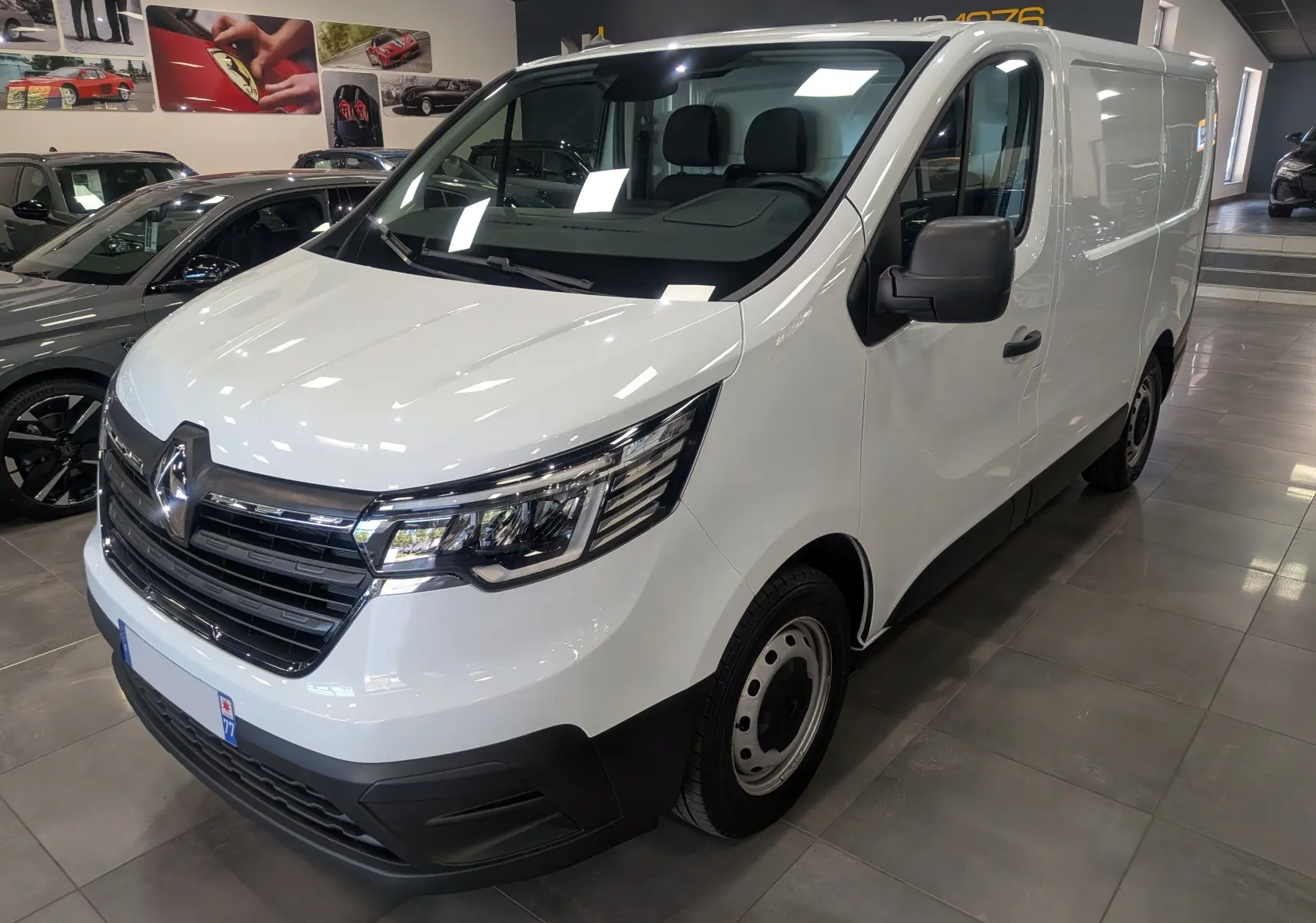 Renault Trafic Fourgon blanc minéral vu en 3/4 avant droit, avec calandre chromée et jantes acier noires.