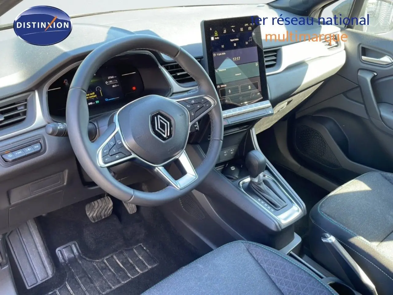 Vue intérieure côté conducteur du Renault Captur E-Tech hybride 2025, avec volant multifonction et écran tactile vertical.