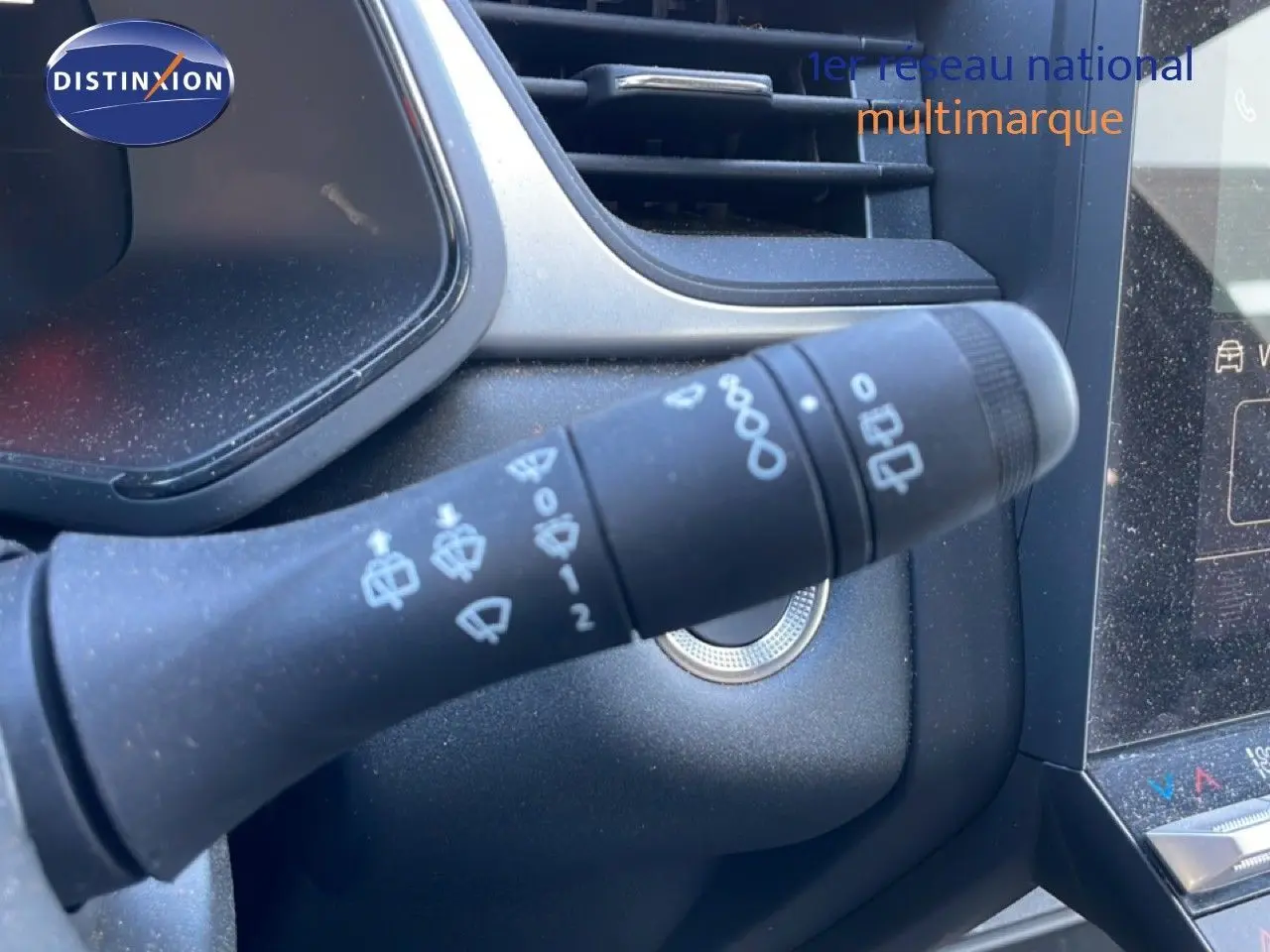 Gros plan sur la commande des essuie-glaces du Renault Captur noir étoile métal, avec tableau de bord et écran tactile partiellement visibles.